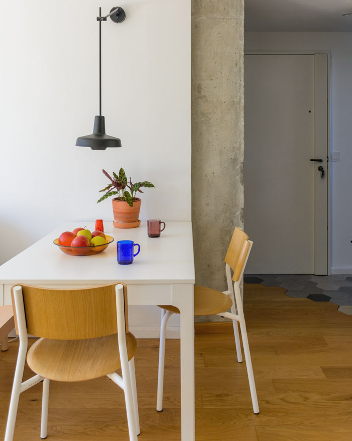 Coin repas rénové avec parquet en bois de chêne et mur en béton brut, Studio Nidu, architecte d’intérieur à Versailles (Yvelines)